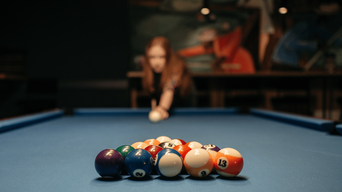 femme jouant au billard dans un bar