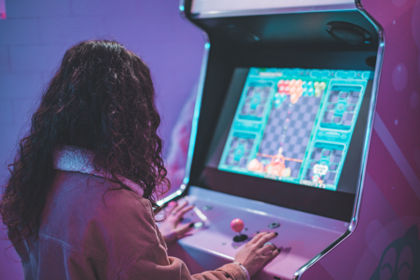 femme jouant sur une borne d'arcade en location pour bureaux