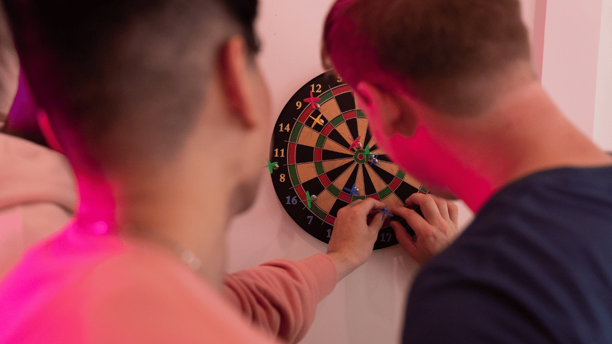deux jeunes hommes jouant aux darts ou fléchettes
